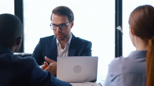 Young director giving new ideas about the project to his business partners alt