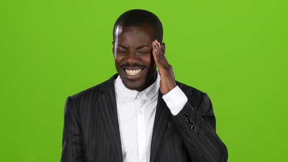 Afroamerican Guy in Costume Experiences a Severe Headache. Green Screen alt