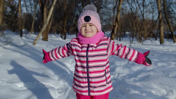 Smiling Child Kid Looking at Camera Embracing Fooling Around Hugging in Winter Snowy Park Forest alt