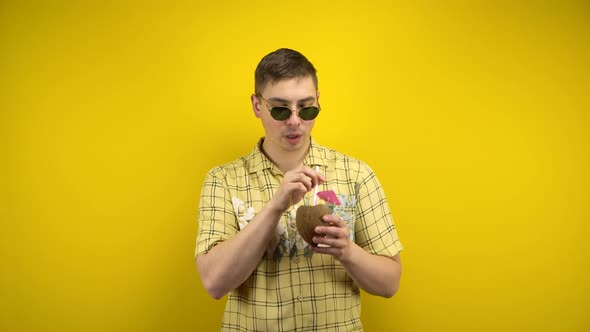 The Man in Sunglasses and a Hawaiian Shirt Is Hot and Drinking Coconut Pina Colada. Shooting in the alt