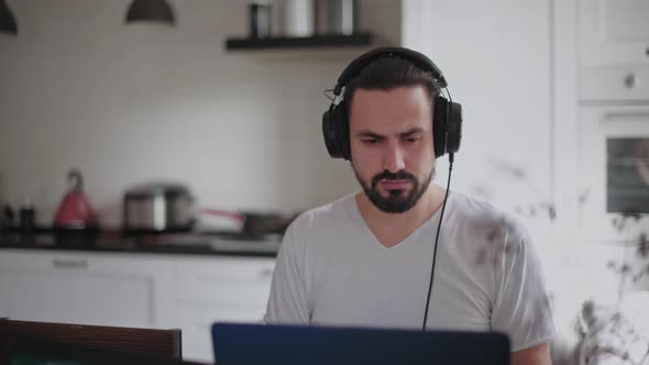 A young man and a young girl are working in front of laptops in their bright apartment. alt