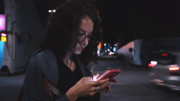 Attractive Woman Using Mobile Phone During Walk on Streets of Night Town alt