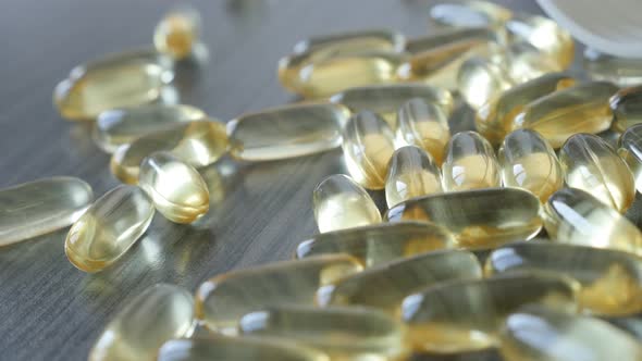 Fish oil suplement on wooden table   4K 2160p 30fps UltraHD panning  footage - Slow pan on transpare alt