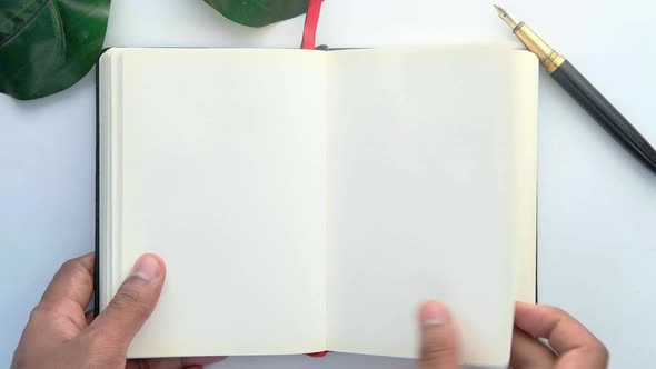 Man's Hand Turning a Pager of a Diary  alt