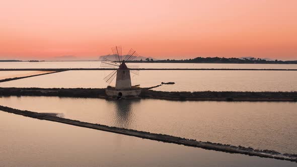 Aerial Drone Orbit of Moulin in Salt Pans of Marsala in Sicily during sunset, Italy 4K