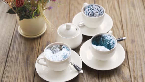 Deep Blue Stormy Ocean Locked Into Small White Cups. Thundery Restless Sea Inside Crockery. Waves alt