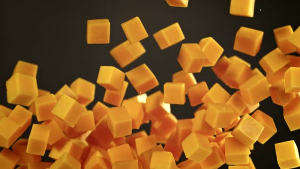 Super Slow Motion Shot of Flying Cheese Cubes on Black Background at 1000 Fps alt