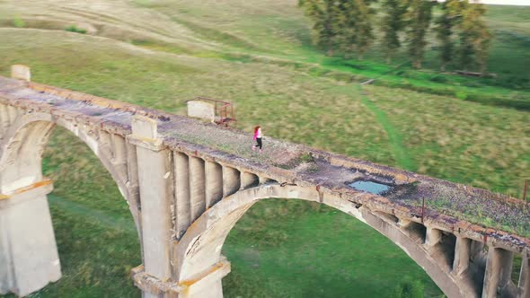 Old Massive Bridge with a Sportswoman Jogging Along It alt
