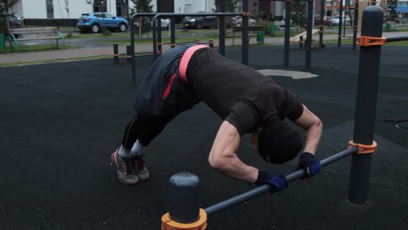 Muscular man training outdoors on sports field