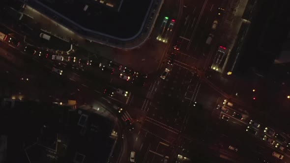 AERIAL: Beautiful Overhead Shot of Busy Intersection at Night with Car Traffic and City Lights  alt