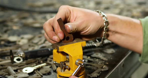 Locksmith in Workshop Attaches New Key