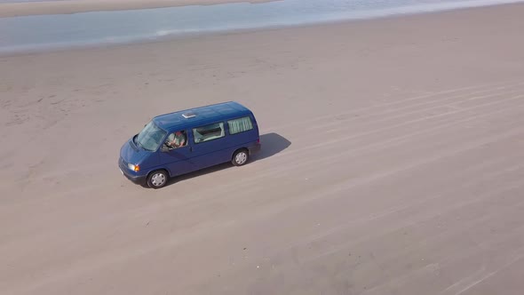 Aerial view of van driving on the beach of borsmose in Denmark