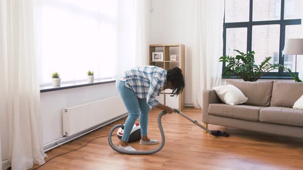 African American Woman with Vacuum Cleaner at Home alt