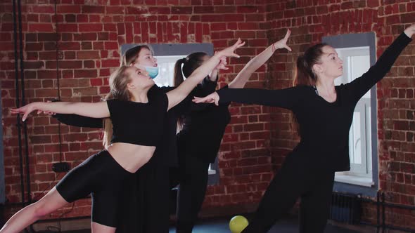 Gymnastics  Three Young Women Having a Training the Trainer Corrects Their Poses alt