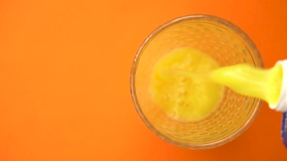 Pouring Orange Juice in the Glass From Top View