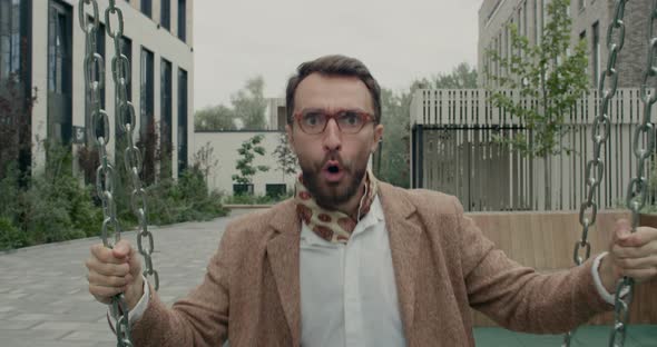 Close Up of Bearded Man in Glasses Swinging and Laughing While Looking To Camera. Happy Businessman alt