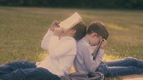 Exhausted Boys Sleep with Books in Hands Preparing for Exam alt