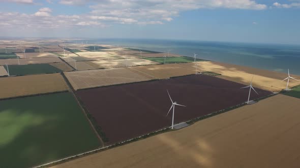 Windmills Produce Lot Energy Against a Beautiful Landscape. Aerial Survey alt
