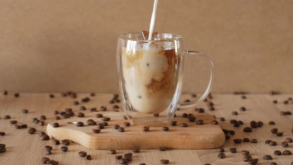 Milk Cream is Poured Into a Iced Coffee alt