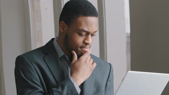 Focused African American Businessman Student Holding Hand on Chin Lost in Thoughts at Work with alt