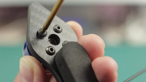 Extreme Close Up of Young Man's Hands Assembling Motor of FPV Racing Drone Using Screwdriver.