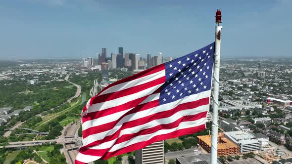 Proud to be an American theme. Houston Texas city skyline. Aerial orbit on windy day. Slow motion. alt
