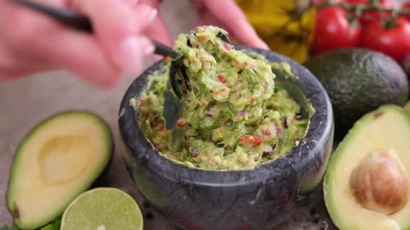 Making Guacamole Sauce  Woman Mixing Chopped Ingredients in Marble Bowl Mortar alt