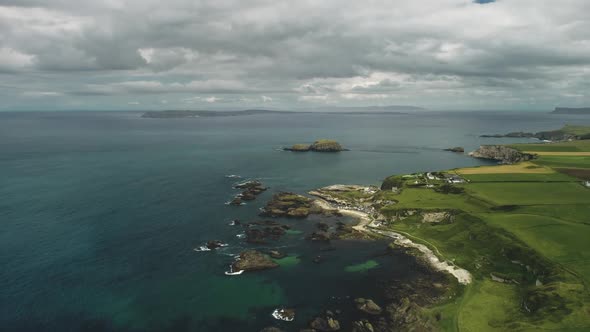 Cliff Aerial Landscape: Rocky Ocean Shore. Irish Distillery Against Nature: Meadows and Clouds alt