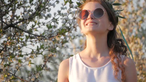 Beauty young woman enjoying nature in spring apple orchard, Happy Beautiful girl in Garden with bloo