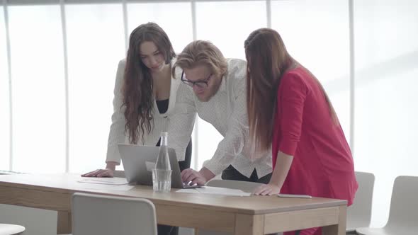 Handsome Blond Man In Glasses Bent Over Netbook In A Light