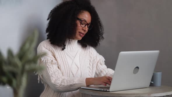 African Woman Young American is Working with Laptop at Table in Modern Office Spbi alt