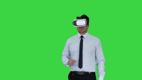 Businessman in VR Glasses and Interacting with Virtual Reality Objects on a Green Screen, Chroma Key alt