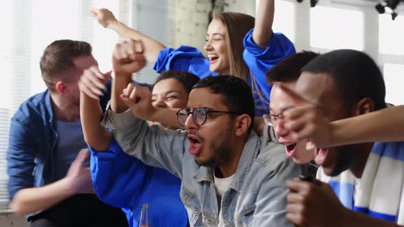 Happy mixed-ethnic friends watching sport game