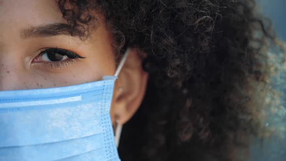Macro Close Up Beautiful American Woman with Blue Protective Mask on Face From Coronavirus Covid alt