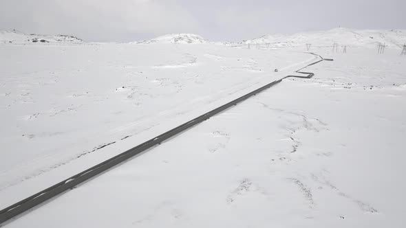 Aerial view of gas pipes through snowy frozen countryside in Iceland