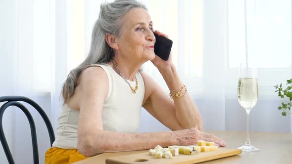Beautiful Old Grandmother with Grey Hair and Face with Wrinkles is Using Smartphone Talking with alt