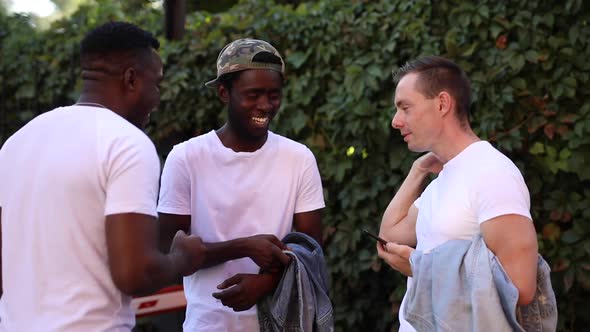 Three Multiracial Friends Chatting and Laughing in the Street