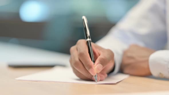 Close Up of African Hands Writing on Paper alt