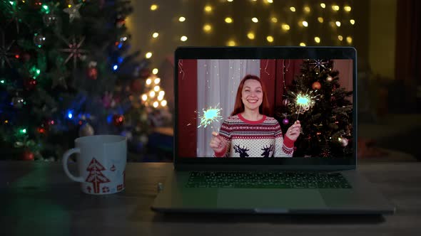 Happy Woman with Sparklers on a Videocall She Is Happy and Wishing a Merry Christmas Online alt