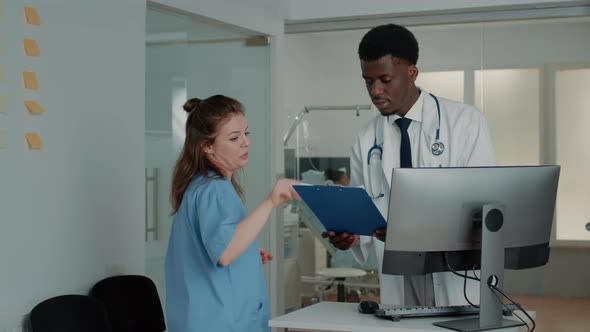 Man Working As Medic Looking at Computer to Find Information alt