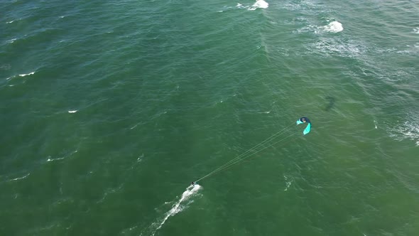 AERIAL: Follow Shot of Isolated Surfer in Green Baltic Sea on Perfect Sunny Weather