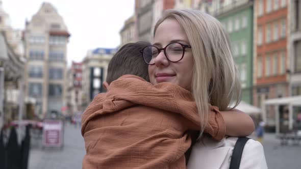 mother and son hugging on the street of Wroclaw, Poland