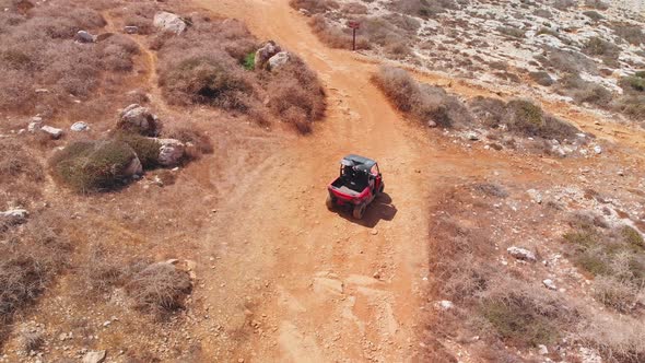 A dune buggy comes to a fork in the road on a dirt path and has to choose a direction alt