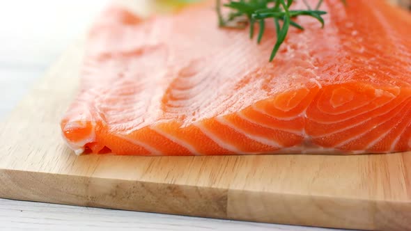 Fresh raw salmon fillet on wooden board, dolly shot