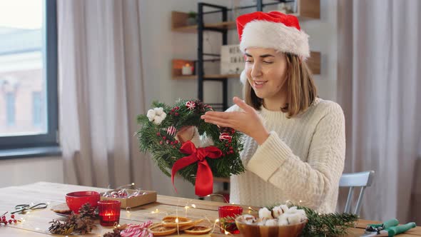 Happy Woman Showing Fir Christmas Wreath at Home