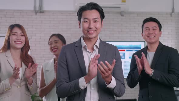 A group of colleagues are clapping their hands in congratulations. alt