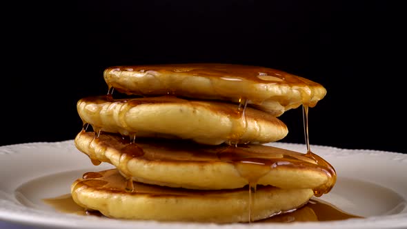 American pancakes with maple syrup on a black background. alt
