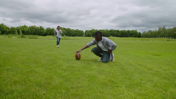 Cheerful Little American Football Player Kicking Free Kick on Pitch alt