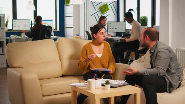 Nervous Businesspeople Yealing at Each Other Sitting on Couch alt