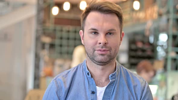 Portrait of Disappointed Casual Man Doing Thumbs Down alt